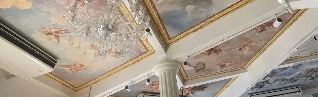 Detail of the frescoed ceiling, gilt frames and a chandelier